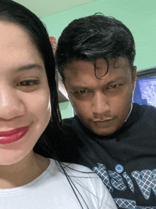 a man and a woman are posing for a picture and the man is wearing a shirt that says ' love '