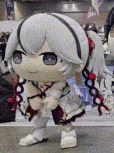 a close up of a stuffed doll with white hair standing on a table