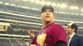 a man in a maroon shirt with a yellow simpson on it