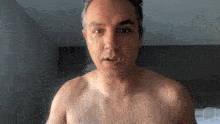 a man without a shirt is looking at the camera with a watermark that says jp