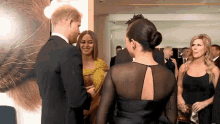 a man in a suit is talking to a woman in a black dress .