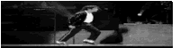 it is a black and white photo of a man dancing on a stage .