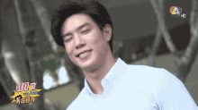 a man in a white shirt is smiling in front of a tv screen that says hd