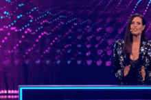 a woman in a sequined dress stands next to another woman on a stage