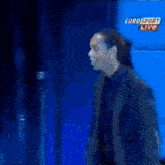 a man stands in front of a blue background with eurosport live written on it