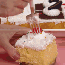 a cake with white frosting and sprinkles is being decorated with a fork