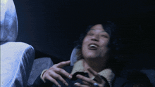 a man is laughing in a dark room with the number 0 on the bottom