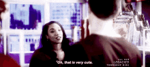 a woman is talking to a man in a store and saying `` oh , that is very cute '' .