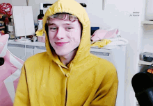 a man wearing a yellow hoodie is smiling in front of a sign that says sweets for rourie