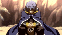 a man in a blue cape sits with his hands folded in front of him