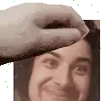 a hand is holding a woman 's head in front of a picture of her face .
