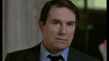 a man in a suit and tie is making a serious face .