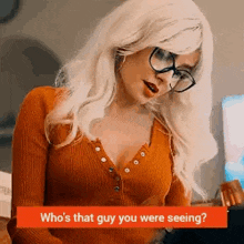 a woman wearing glasses and a wig is sitting at a table and talking to someone .