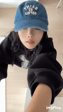 a woman wearing a blue hat that says thiab sg aih908