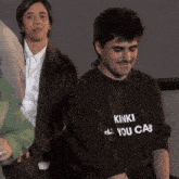 a man wearing a kinki you cab shirt
