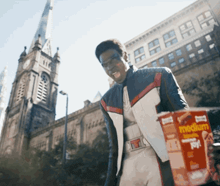 a man in a superhero costume is holding a box of medium chicken pot pie