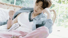 a young man is laying on a couch with his eyes closed while holding a string
