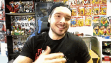 a man wearing a hat is smiling in front of a wall full of toys