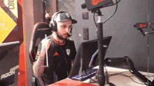 a man wearing headphones is sitting in front of a monitor that says agon on it