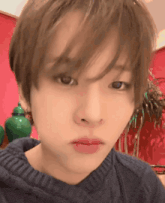 a close up of a person 's face with a blue sweater on .