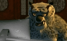 a cartoon leopard is sitting in front of a computer screen .