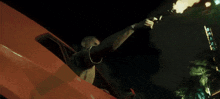 a man is holding a gun in front of a sign that says ' a ' on it