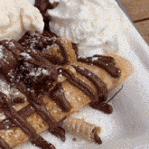 a close up of a dessert with whipped cream and chocolate sauce