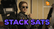 a woman in a military uniform is giving a thumbs up with the words stack sats behind her