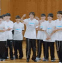 a group of young people are standing in a line on a gym floor .