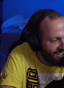a man wearing headphones and a yellow shirt that says wwe on the arm