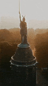 a statue of a man holding a sword is on top of a dome