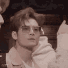 a man wearing sunglasses and a hoodie is looking at something .