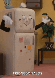 a cartoon refrigerator with a face and arms is standing in a kitchen .