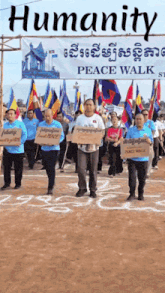 a group of people are marching in front of a sign that says humanity