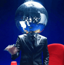a man in a suit and tie has a disco ball on his head