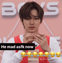 a young man with a sticker that says " he mad asfk now " on it