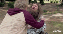 a man with a beard is hugging another man