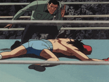a boxer is laying on the ground in a boxing ring