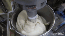 a mixer is being used to mix a dough and the words made in animotica are on the bottom