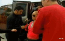 a man in a red shirt is talking to a woman