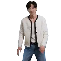 a man wearing a white cardigan and blue jeans