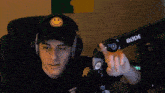 a young man wearing headphones and a rode microphone