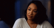 the woman is wearing a white sweater and a necklace .