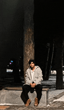 a man is sitting on a bench in the dark