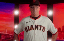 a man wearing a giants jersey and a sf hat