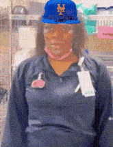a woman wearing a blue hat with the letter m on it .