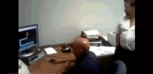 a man sitting at a desk in front of a computer with a snake on it