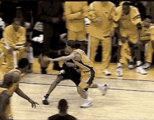 a basketball player is dribbling the ball while another player tries to block him .
