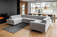 a living room with a large sectional couch and a dining table