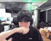 a man wearing headphones and a black shirt that says com